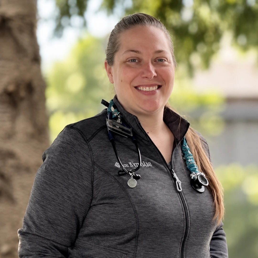 Claressa Salsbury, smiling outside posing by a tree